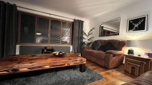 a living room with a couch and a coffee table at Carn A Chuilinn House in Fort Augustus