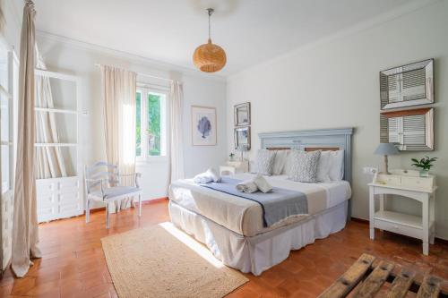 a white bedroom with a bed and a chair at Villa en Marbella Artola&Friends in Marbella