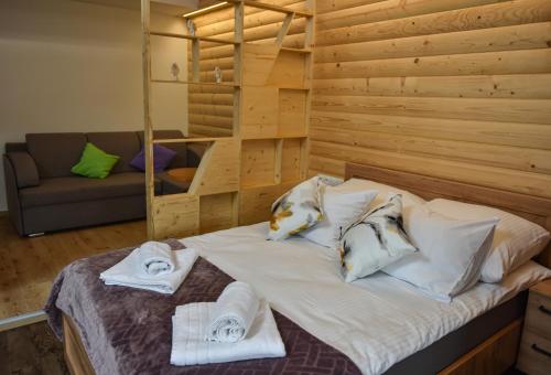 - une chambre avec un lit et des serviettes dans l'établissement Willa POGOŃ ZD12, à Krynica-Zdrój