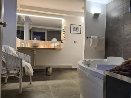 a bathroom with a tub and a sink and a mirror at Le Relais de l'endormie in Nogent-sur-Seine