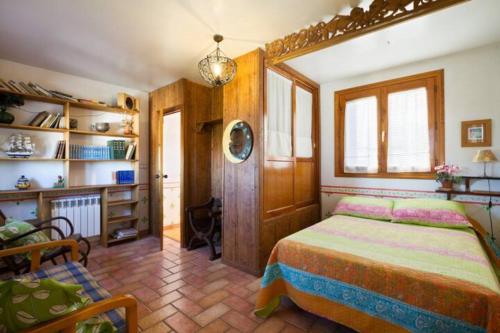 una camera con un letto e una sedia di La Posada del Gato a Monachil