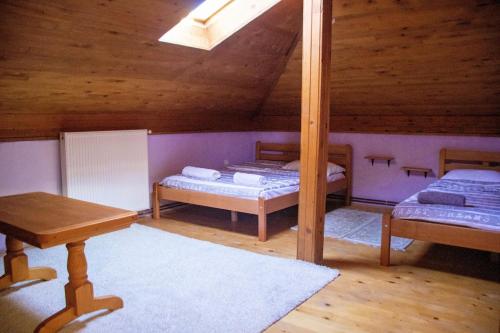 a attic room with two beds and a table at Holiday Home Green in Rakovica