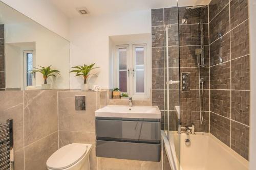 a bathroom with a sink and a toilet and a shower at Langston House: 2 Bed, 2 Bath Luxury Apartment in Hedgerley