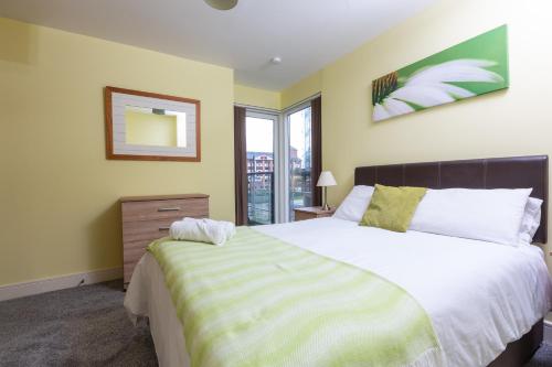 a bedroom with a large bed and a window at Meridian Bay Apartment in Swansea