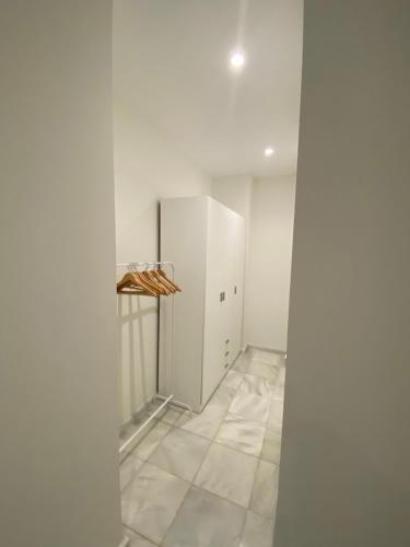 um quarto vazio com um frigorífico e piso em azulejo em C Ciruelo 7 em Lora del Río