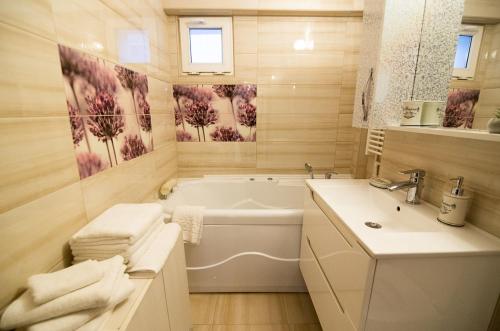 a white bathroom with a tub and a sink at Bota Apartments in Vulcan