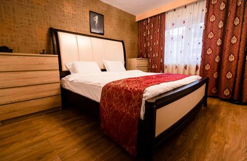 a bedroom with a bed with a red blanket on it at Bota Apartments in Vulcan