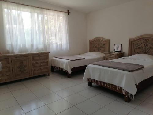 ein Hotelzimmer mit 2 Betten und einem Fenster in der Unterkunft Quinta Valentina Morelos in Temixco