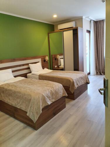 a hotel room with two beds and a mirror at The Fresh Wave hotel in Batumi