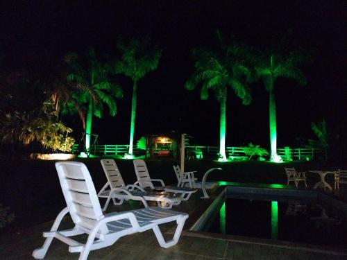 two lawn chairs and a table with green lights at Contempla Joanópolis in Joanópolis