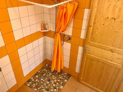 a bathroom with a shower with an orange shower curtain at Agriturismo Le Essenze - Terrazza sulla Romagna in Cesena