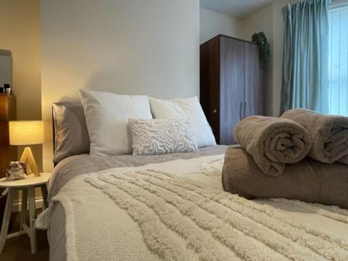 a bedroom with a large bed with towels on it at Townhouse close to Liverpool City Centre - 4 bedrooms in Liverpool
