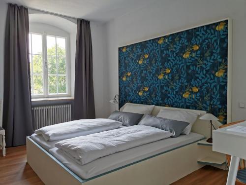 a bedroom with a bed with a blue wall at Klosterwirt Polling in Polling