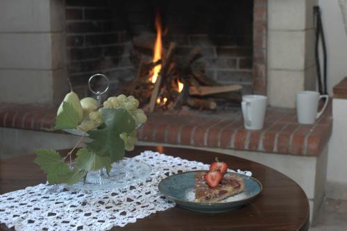 a table with a plate of food next to a fireplace at Αργουλιάς in Tzermiádon