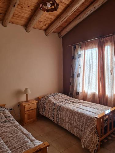 a bedroom with two beds and a window at Colorina - El Nihuil in El Nihuil