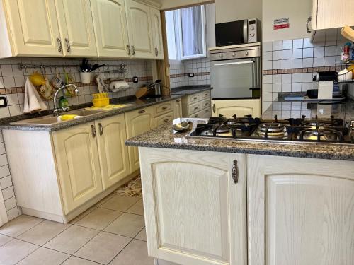 a kitchen with white cabinets and a stove top oven at Agriturismo Le Essenze - Terrazza sulla Romagna in Cesena