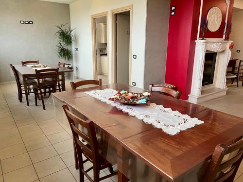 a dining room with a wooden table and chairs at Agriturismo Le Essenze - Terrazza sulla Romagna in Cesena