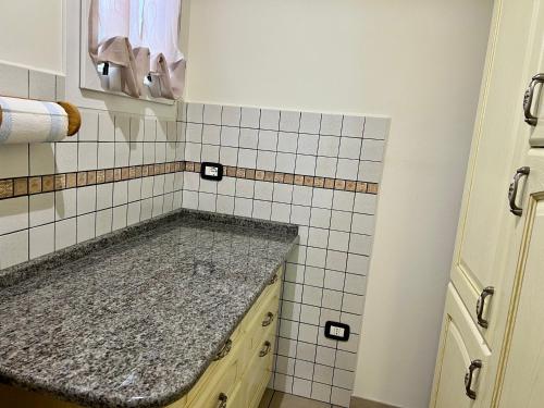 a bathroom with a sink and a tiled wall at Agriturismo Le Essenze - Terrazza sulla Romagna in Cesena