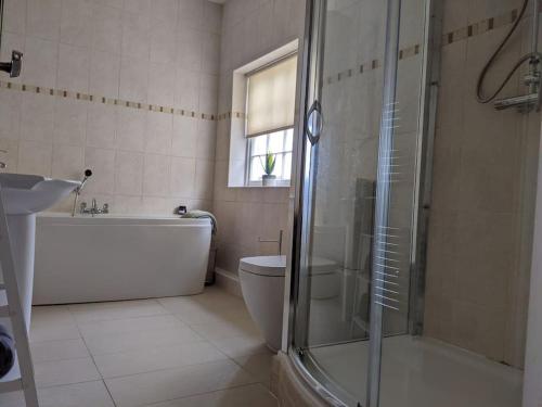 La salle de bains est pourvue d'une douche, d'une baignoire et de toilettes. dans l'établissement Beautiful Georgian townhouse in central Colchester, à Colchester