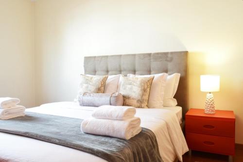 a bedroom with a large bed with towels on it at Perola, a Home in Madeira in Funchal