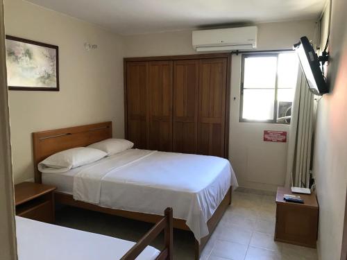 um pequeno quarto com uma cama e uma janela em Apartamento Los Laureles Rodadero em Santa Marta