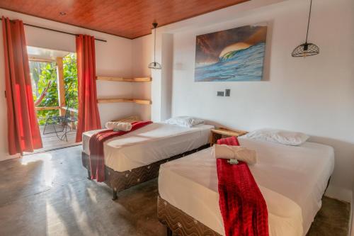 two beds in a room with a window at Esencia Nativa in El Zonte