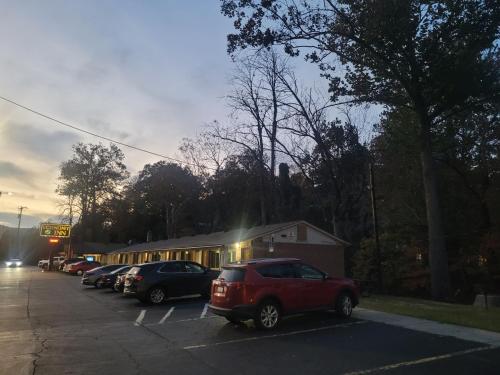 a parking lot with cars parked in front of a building at Economy Inn Sylva in Sylva