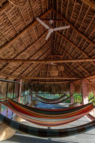 a hammock under a straw roof with a ceiling at Esencia Nativa in El Zonte