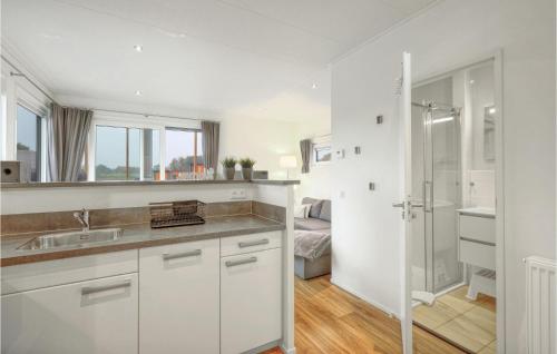eine weiße Küche mit einem Waschbecken und einer Dusche in der Unterkunft Chalet Sonnenschein in Süsel
