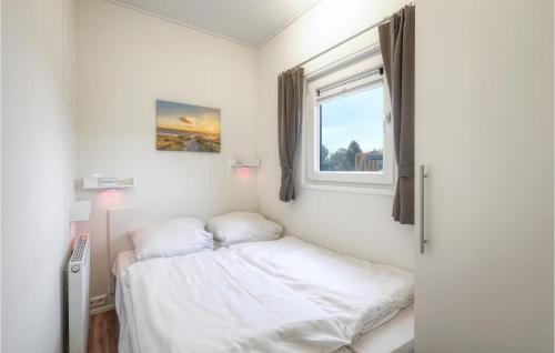 ein kleines Schlafzimmer mit einem Bett und einem Fenster in der Unterkunft Chalet Sonnenschein in Süsel