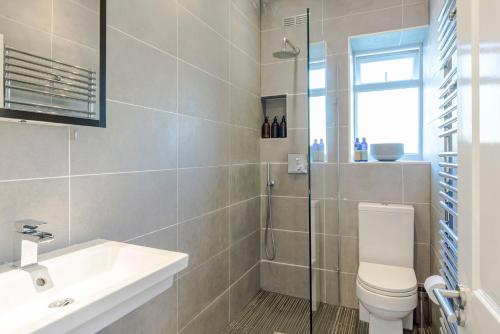 ein Bad mit einem WC, einem Waschbecken und einer Dusche in der Unterkunft The Dalston Maisonette in London