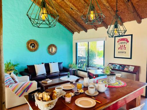 a living room with a table and a couch at Posada de la Viuda in Punta Del Diablo