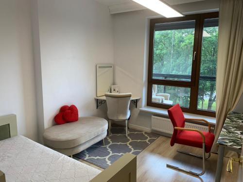 ein Schlafzimmer mit einem Bett, einem Stuhl und einem Fenster in der Unterkunft Uroczy apartament 2 osobne pokoje Marina Royal Palace in Warschau
