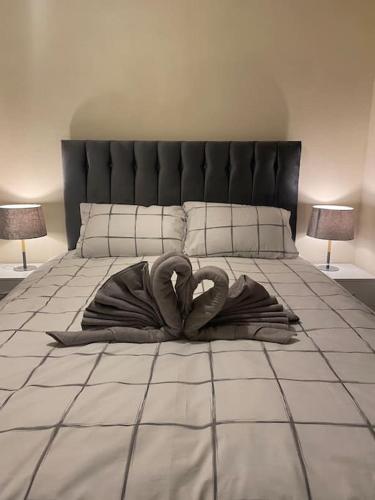 two swans laying on a bed with two lamps at 3 bedroom home-inverkeithing in Fife