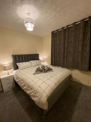 a bedroom with a bed with a bow on it at 3 bedroom home-inverkeithing in Fife