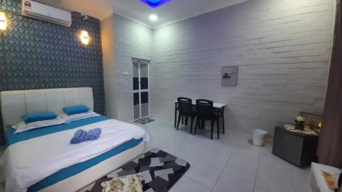 - une chambre avec un lit, une table et des chaises dans l'établissement GekQ Inn Langkawi B, à Pantai Cenang
