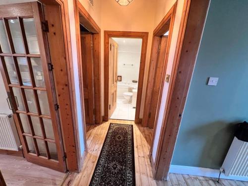 - un couloir menant à une salle de bains pourvue de toilettes dans l'établissement Victorian apartment, central location with free parking., à Perth