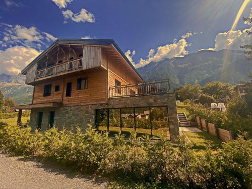 a wooden house with a balcony on top of a hill at Chalet Amour blanc Chamonix Les Houches in Les Houches
