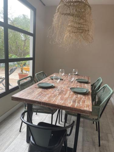 a dining room table with chairs and a chandelier at Pureza del Hueznar in Cazalla de la Sierra