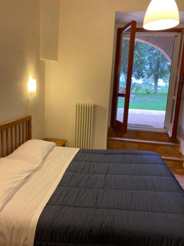 Un dormitorio con una cama grande y una ventana en Casale in collina vista Assisi,Brufa di Torgiano en Brufa