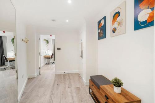 - un salon avec des murs blancs et une table en bois dans l'établissement Modern 2 bedroom apartment in the heart of London, à Londres