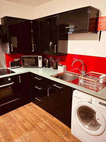 a kitchen with a sink and a washing machine at 'Woodbury' at stayBOOM in Lancaster