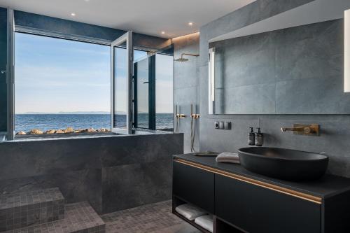 a bathroom with a sink and a view of the ocean at Bay View Apartments in Gardur