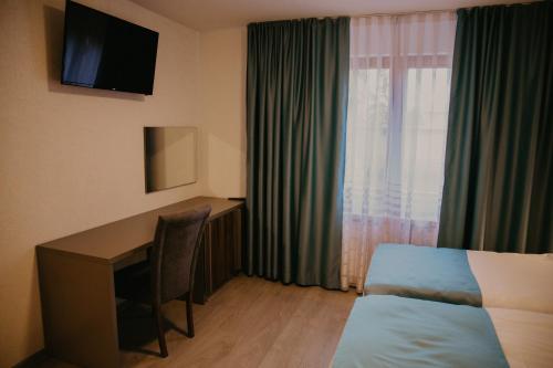 Habitación de hotel con escritorio, cama y ventana en Saray&App en Sarajevo