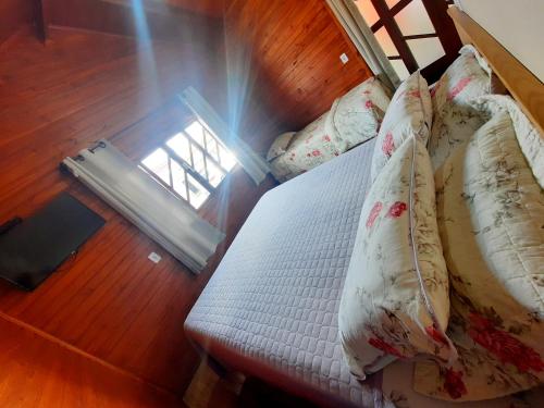 a bed with pillows on it in a room at Pousada Morada dos Sonhos in Urubici