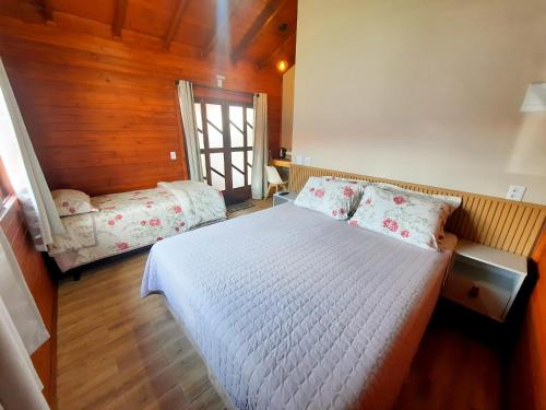 a bedroom with a white bed in a room at Pousada Morada dos Sonhos in Urubici