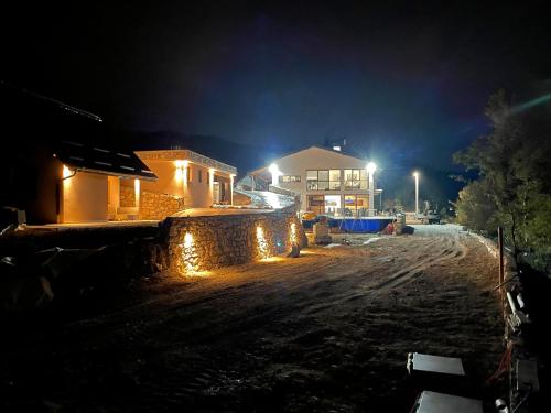 a house with lights on a dirt road at night at Josanica Bed&Breakfast in Konjic