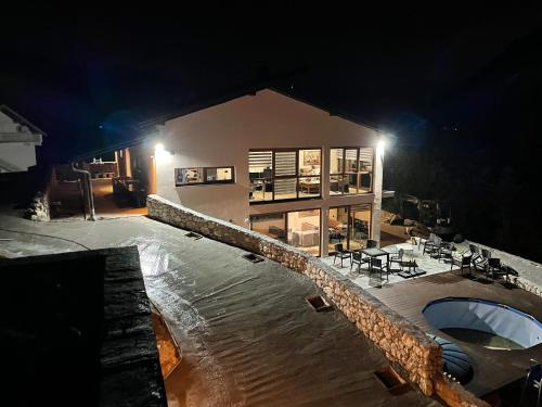 a building with a swimming pool at night at Josanica Bed&Breakfast in Konjic