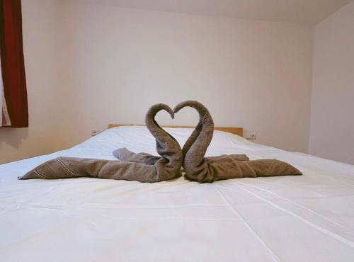 Altach的住宿－Frog’s Palace 2，两只蛇在床上形成心