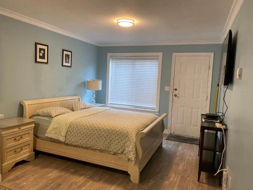 a bedroom with a bed and a window at jane's cozy suite in Surrey